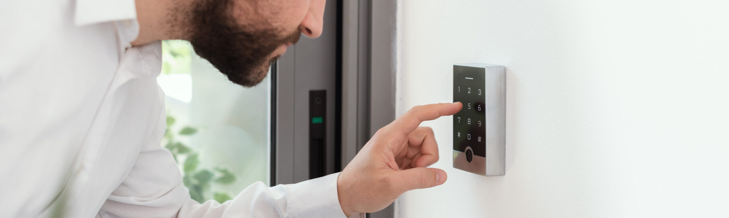 Man Setting An Alarm Code For Home Security